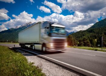 fuel truck rushes down the highway in the background the alps truck car in motion blur