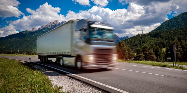 fuel truck rushes down the highway in the background the alps truck car in motion blur